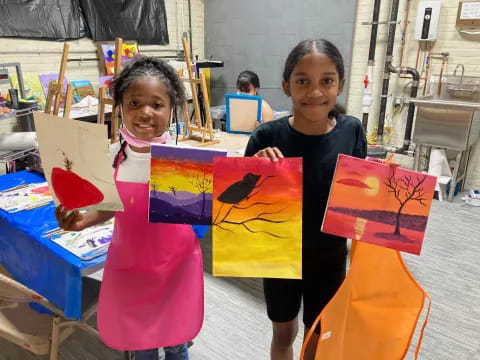 a couple of girls holding colorful paper