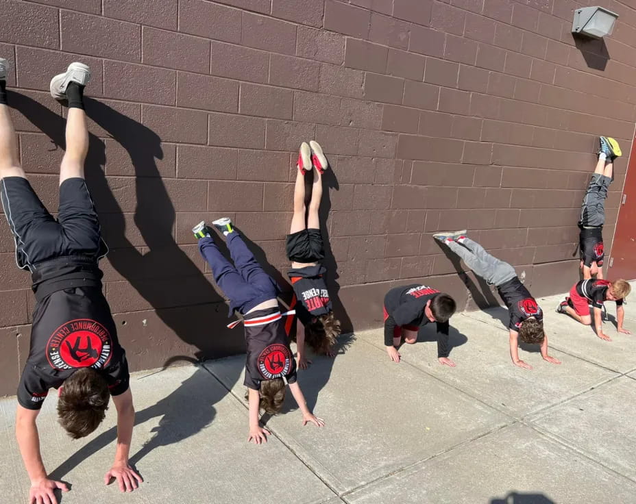 a group of people doing handstands on a brick surface