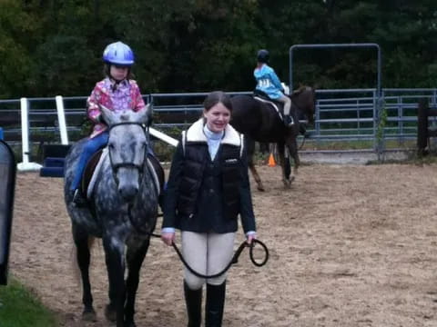 a person leading a girl on a horse