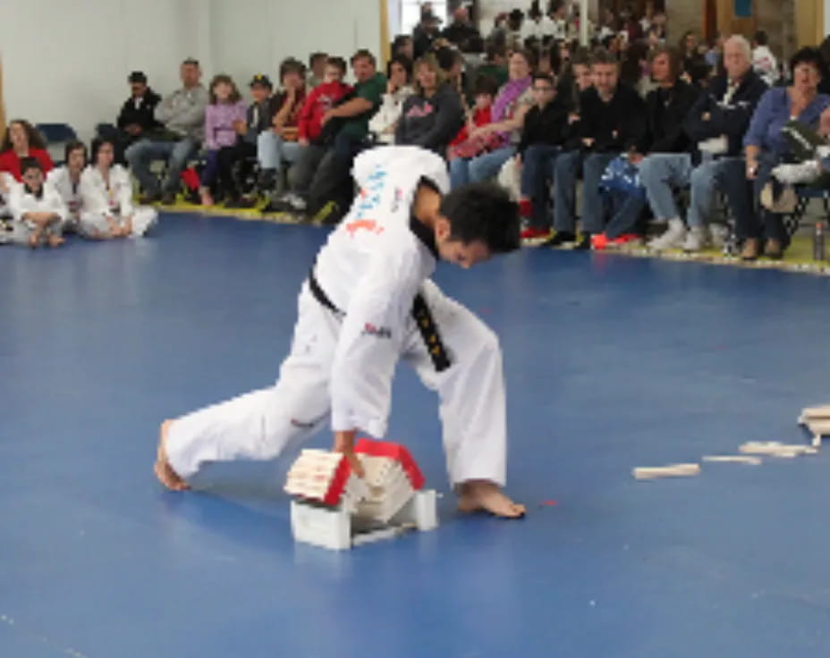 a person in a karate uniform kicking another man in the face