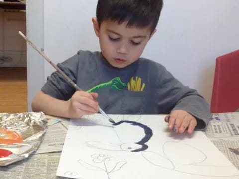 a boy drawing on a piece of paper
