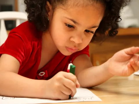 a child writing on a piece of paper