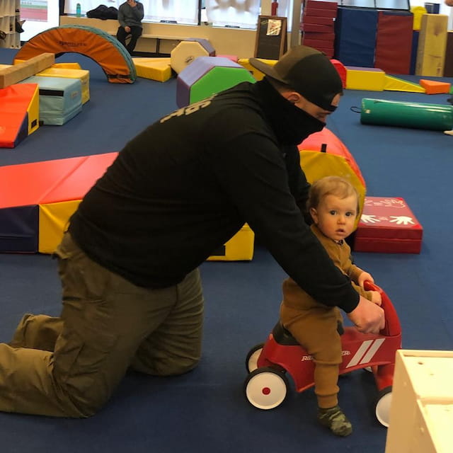 a person and a child playing on a toy train