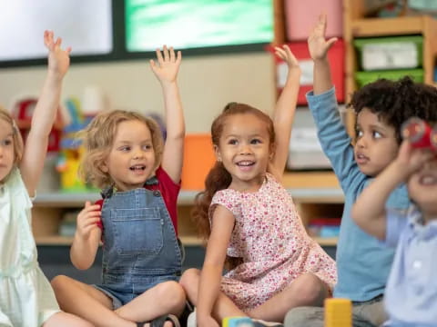 a group of children raising their hands
