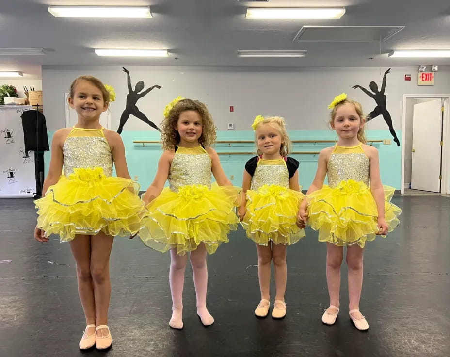 a group of girls in yellow dresses