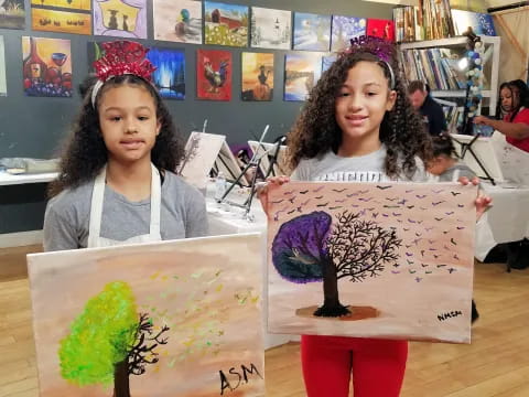 a couple of girls holding a drawing