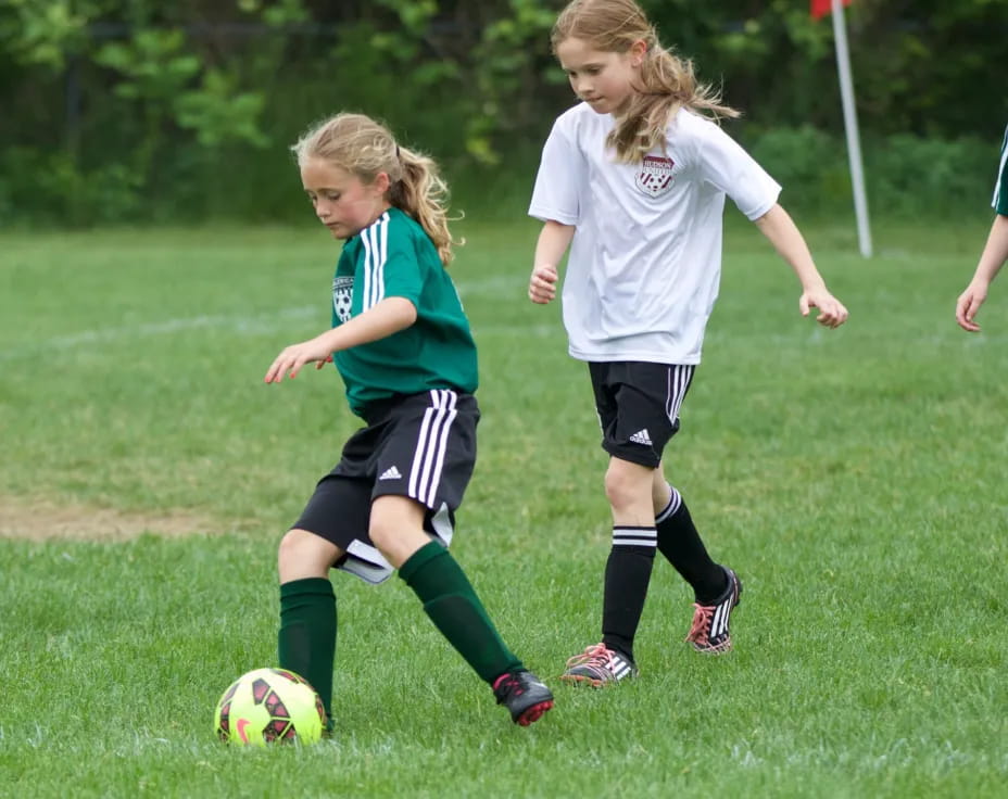 girls playing football on a field