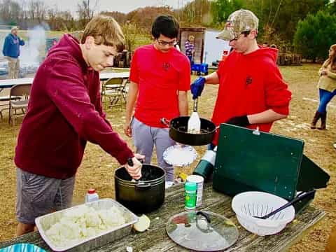a group of people cooking outside