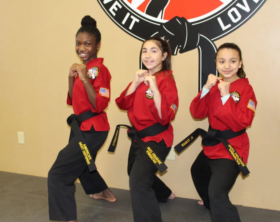 a group of women in red karate uniforms posing for a photo