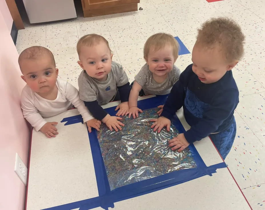 a group of children playing with a blue plastic tub