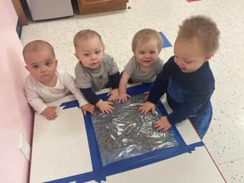 a group of children playing with a blue plastic tub