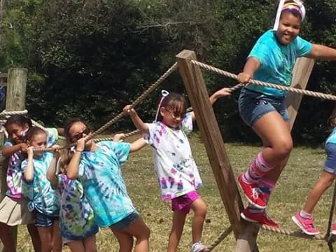a group of children playing on a wooden structure