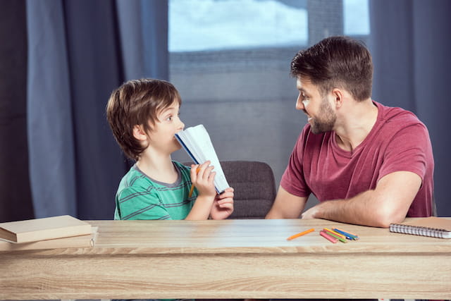 a person and a child looking at a paper