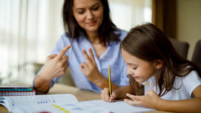 a woman and a child looking at a paper