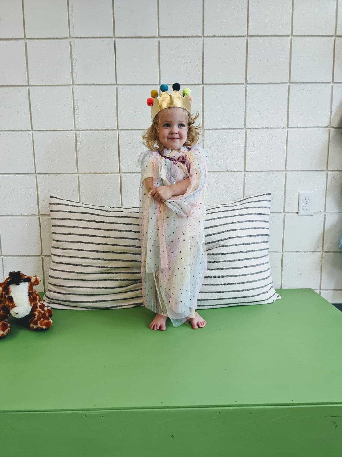 a girl standing next to a baby