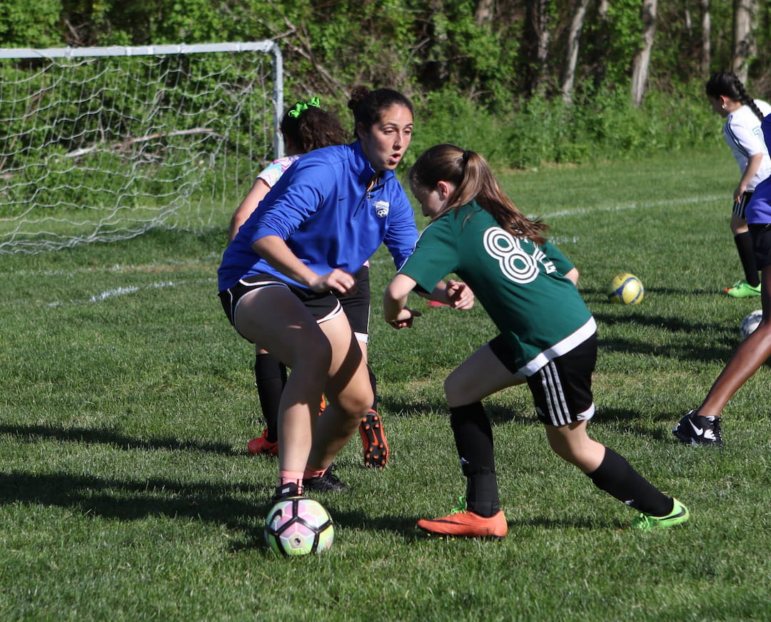 girls playing football on a field