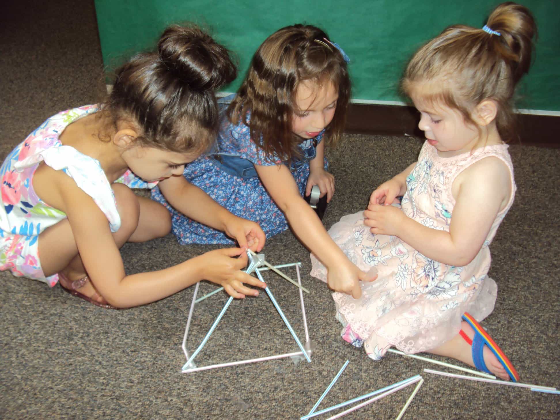 a group of young girls playing with a toy