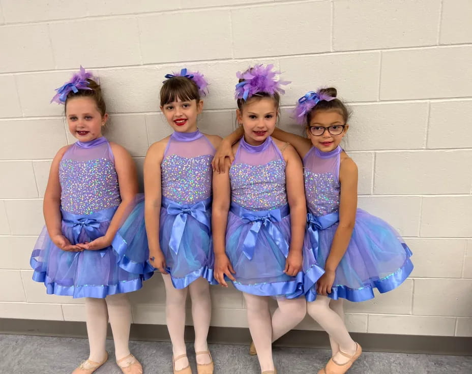 a group of girls in blue dresses