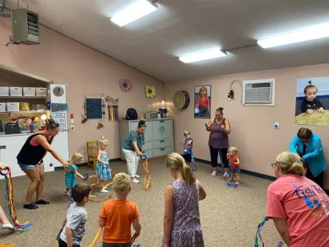 a group of people playing with toy swords in a room