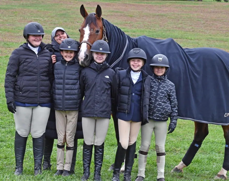 a group of people posing for a photo with a horse