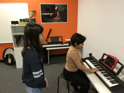 a couple of people playing piano