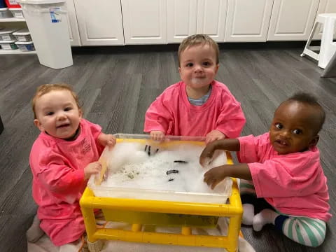 a group of children playing with a yellow table