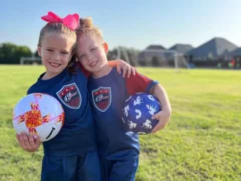 a couple of girls holding a ball