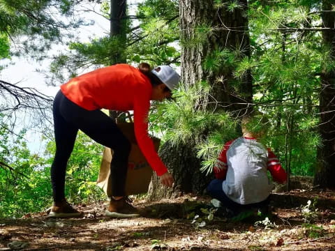 a person helping another man in the forest
