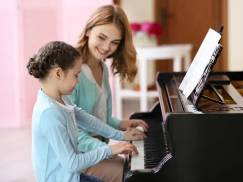 a person and a boy playing piano