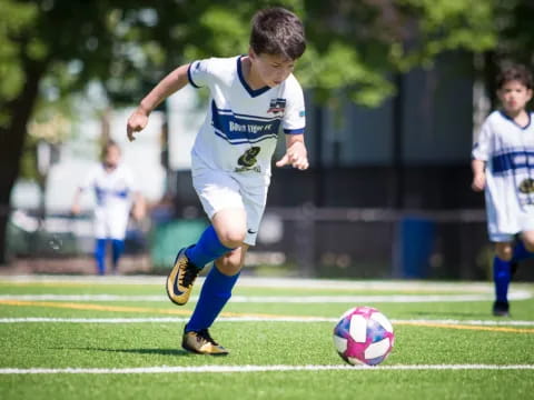 a boy kicking a football ball