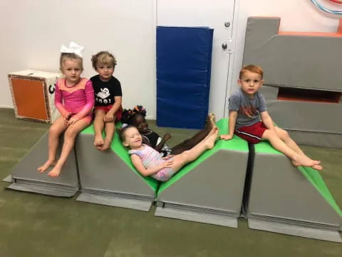 a group of children sitting on a trampoline