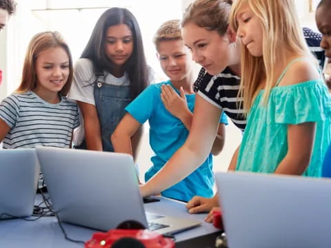 a group of people looking at a laptop