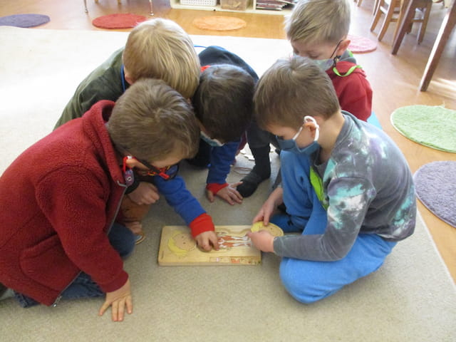 a group of children playing with a puzzle