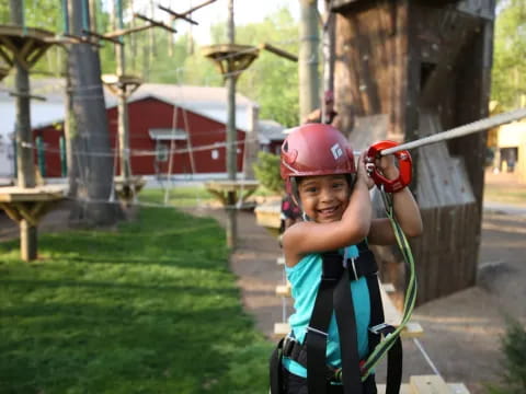 a boy wearing a helmet and climbing a tree