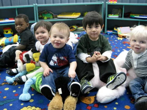 a group of kids sitting on the floor with toys
