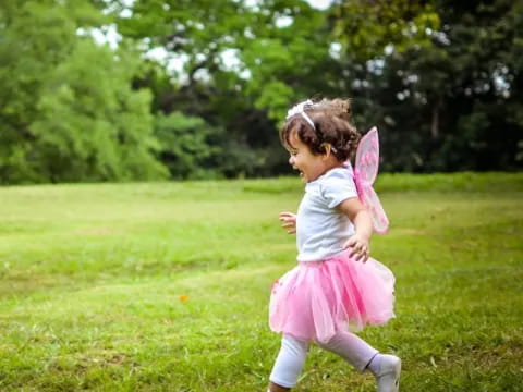 a little girl walking in a grassy area