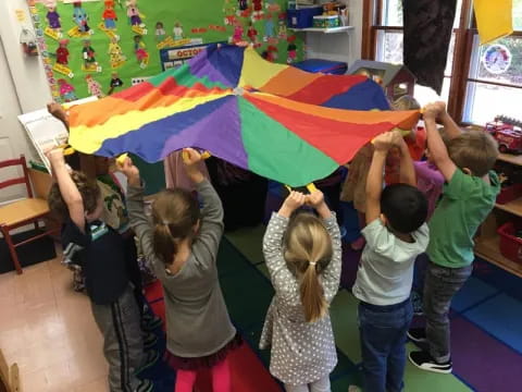 a group of children holding a rainbow flag