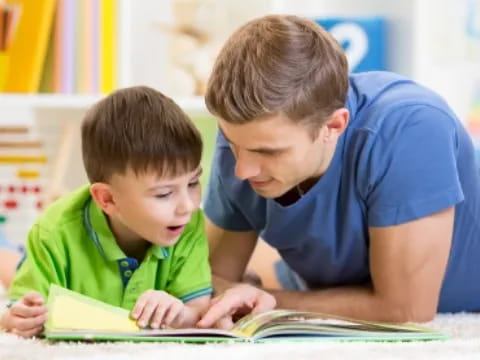 a person and a boy looking at a book