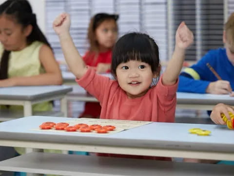 a young girl raising her hands