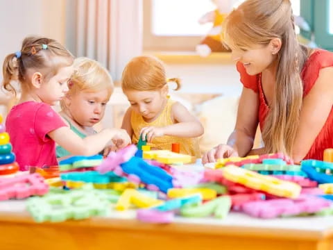 a group of children sitting at a table with colorful paper crafts