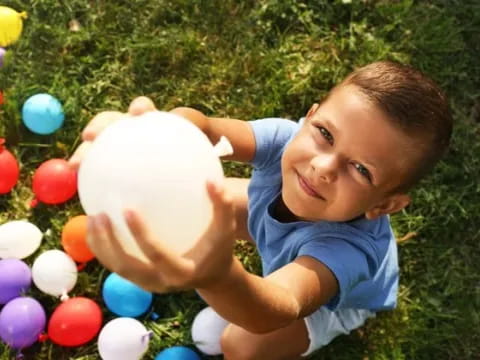 a boy lying on the ground with a ball in his hand