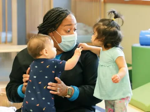 a person and two children wearing face masks