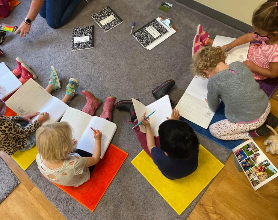 a group of children sitting on the floor reading books