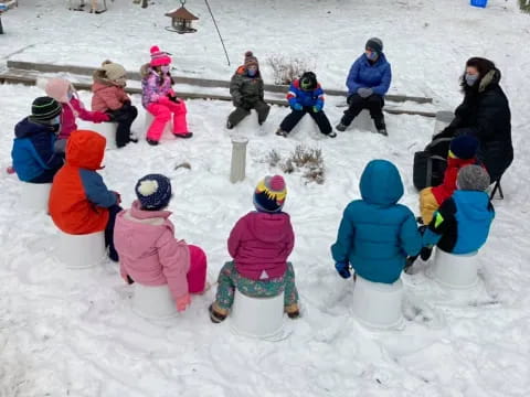 a group of people sitting in the snow