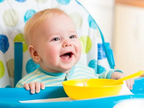 a baby in a yellow bucket