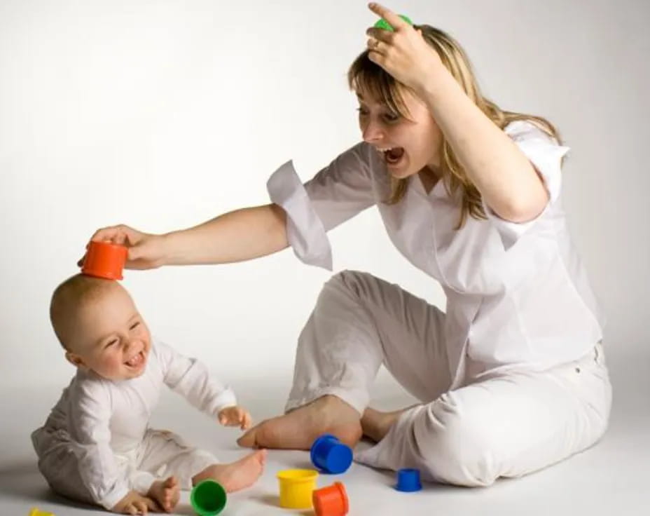 a woman playing with a baby