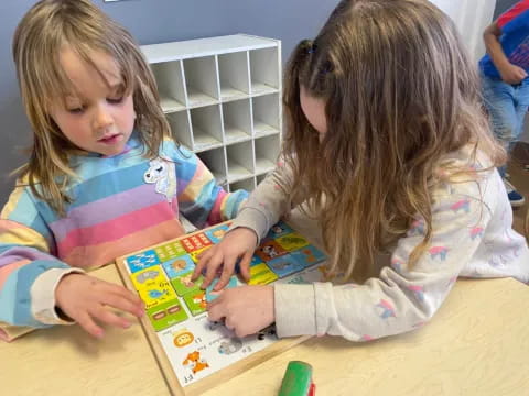 a couple of young girls playing with a toy