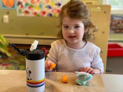 a little girl sitting at a table