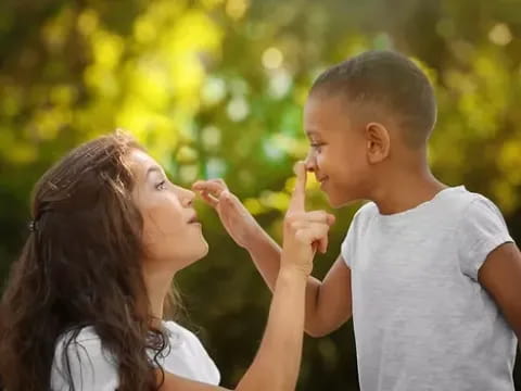 a woman and a boy kissing