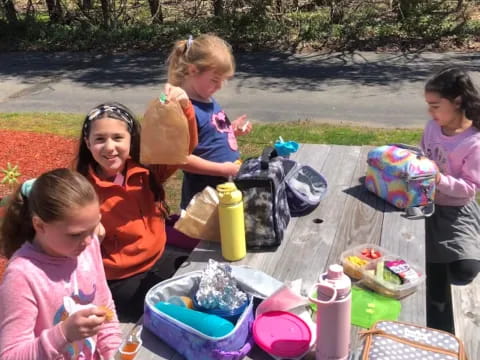 a group of girls sitting at a picnic table